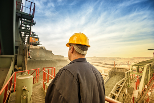 Coal,Mine,Engineer,With,A,Helmet,Standing,On,A,Huge