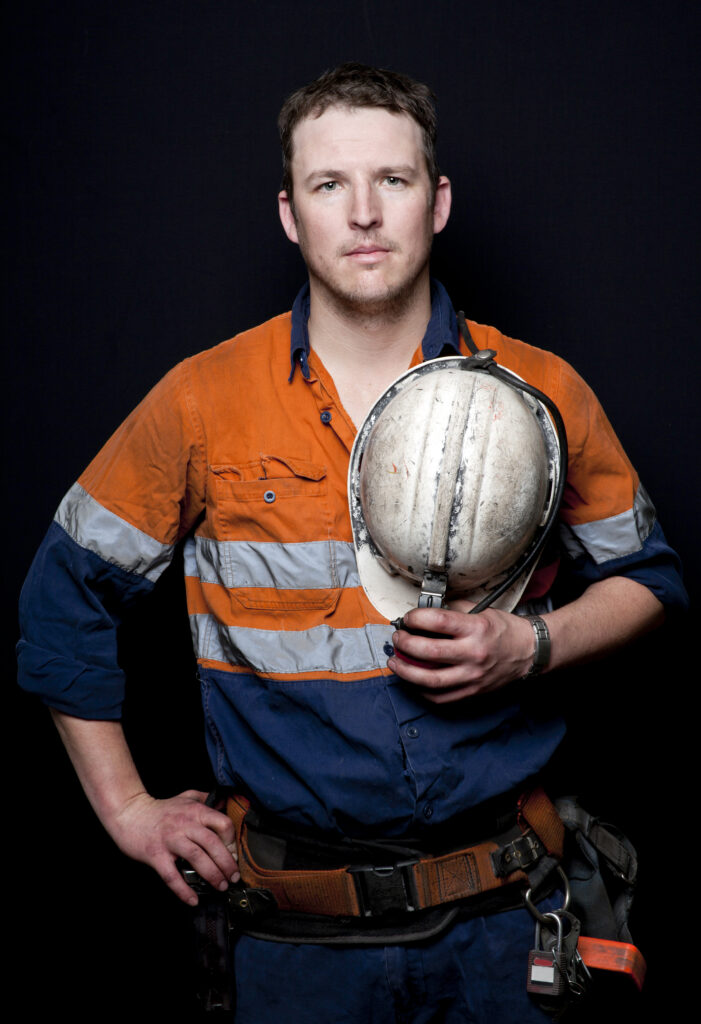 Man,With,Coal,Miner,Hat,And,Safety,Clothing,,Black,Background